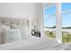 Bright main bedroom with a view from the large window, soft bedding, and stylish accents at 12261 Farmview St, Thornton, CO 80241