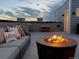 Cozy rooftop deck with a fire pit, comfortable seating, and ambient lighting at 12261 Farmview St, Thornton, CO 80241