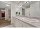 Bathroom vanity featuring white cabinetry, a large mirror, and tiled flooring at 3502 S Kittredge St # C, Aurora, CO 80013