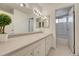 Bathroom vanity featuring white cabinetry, a large mirror, and tiled flooring at 3502 S Kittredge St # C, Aurora, CO 80013