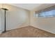 Neat bedroom with neutral color, carpet flooring, a lamp, and a window with outside view at 3502 S Kittredge St # C, Aurora, CO 80013