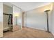 Comfortable bedroom featuring carpet flooring, a closet with mirror doors, and a lamp at 3502 S Kittredge St # C, Aurora, CO 80013