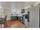 Bright kitchen featuring stainless steel appliances, lower sage-green cabinets, white upper cabinets, and wood-look flooring at 3502 S Kittredge St # C, Aurora, CO 80013