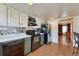 Bright kitchen featuring stainless steel appliances, lower sage-green cabinets, white upper cabinets, and wood-look flooring at 3502 S Kittredge St # C, Aurora, CO 80013