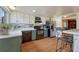 Bright kitchen featuring stainless steel appliances, lower sage-green cabinets, white upper cabinets, and wood-look flooring at 3502 S Kittredge St # C, Aurora, CO 80013