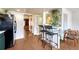 View of the kitchen passthrough to seating area with black bar stools, wood-look floors, and white walls at 3502 S Kittredge St # C, Aurora, CO 80013