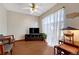 Living room with ceiling fan, large window with sheer curtains, entertainment center and wood look floors at 3502 S Kittredge St # C, Aurora, CO 80013