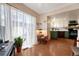 Living room with large window with sheer curtains and passthrough to bright kitchen with white upper and sage-green lower cabinets at 3502 S Kittredge St # C, Aurora, CO 80013