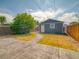 Backyard featuring gray siding, green grass, stone patio, and a garage at 541 Fox St, Denver, CO 80204