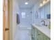 Bathroom featuring a tub and shower with white subway tile, hexagon tile floors, and light green vanity at 541 Fox St, Denver, CO 80204