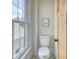 Cozy powder room with a traditional toilet, hardwood door, and bright window at 541 Fox St, Denver, CO 80204