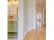 Hallway featuring wood floors and a partial view of a bathroom with a light green vanity at 541 Fox St, Denver, CO 80204