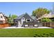 Charming gray home featuring an outdoor living space with seating and an expansive artificial lawn at 420 N Colorado Blvd, Denver, CO 80206