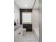 Stylish bathroom with a stone accent wall, glass block window, and marble tile flooring, showcasing modern elegance at 420 N Colorado Blvd, Denver, CO 80206