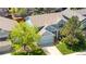 Aerial view of a two-story home featuring mature landscaping, a two car garage, and blue siding at 3102 White Oak Trl, Highlands Ranch, CO 80129