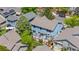 Aerial view of a blue two-story home with a well-manicured lawn, patio, and mature trees at 3102 White Oak Trl, Highlands Ranch, CO 80129