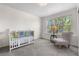 Bedroom with crib and soft chair near a bright window; fresh, neutral decor at 3102 White Oak Trl, Highlands Ranch, CO 80129