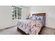 Bedroom featuring a queen size bed, large window, soft carpet, and traditional nightstand at 3102 White Oak Trl, Highlands Ranch, CO 80129