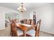 Formal dining room featuring a wood table, six chairs, chandelier, and access to other living spaces at 3102 White Oak Trl, Highlands Ranch, CO 80129