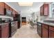 Open kitchen with dark wood cabinetry, connecting to an eat-in area with natural light and outdoor views at 3102 White Oak Trl, Highlands Ranch, CO 80129