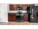 Efficient kitchen layout with dark wood cabinets and stainless steel appliances, maximizing space and functionality at 3102 White Oak Trl, Highlands Ranch, CO 80129