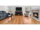 Comfortable living area featuring hardwood floors, a cozy fireplace, and large windows for natural light at 3102 White Oak Trl, Highlands Ranch, CO 80129