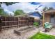 Charming backyard with raised garden beds, a cozy bench with cushions, and a rustic wooden fence at 1811 S Yank Ct, Lakewood, CO 80228