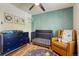 Stylized Bedroom features blue paneled accent wall, crib, and glider at 1811 S Yank Ct, Lakewood, CO 80228