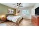 Bright bedroom with hardwood floors, ceiling fan, and artwork at 1811 S Yank Ct, Lakewood, CO 80228