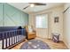 Bright Bedroom with hardwood floors, a crib, and a glider at 1811 S Yank Ct, Lakewood, CO 80228