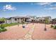 Serene backyard featuring a covered patio, lush lawn, and artistic rock landscaping at 3022 Merlin Dr, Brighton, CO 80601