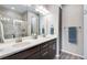 Modern bathroom showcasing double sinks, updated cabinets, and a luxurious glass-enclosed shower at 3022 Merlin Dr, Brighton, CO 80601
