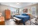 A bright bedroom filled with natural light, featuring wood floors and a blue comforter on the bed at 3022 Merlin Dr, Brighton, CO 80601