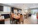 Open-concept kitchen with stainless steel appliances, dark cabinets, and island seating adjacent to the dining area at 3022 Merlin Dr, Brighton, CO 80601