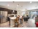 Modern kitchen featuring an island with bar seating, stainless steel appliances, and a seamless transition to the living area at 3022 Merlin Dr, Brighton, CO 80601