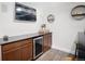 Finished basement with bar area that includes a wine fridge and dark cabinets at 15502 E Flower Mound Pl, Parker, CO 80134