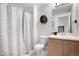 Clean bathroom features a shower with patterned curtain and a wood-tone vanity at 15502 E Flower Mound Pl, Parker, CO 80134