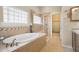 Bright bathroom features a soaking tub, glass shower, and neutral tile surround at 15502 E Flower Mound Pl, Parker, CO 80134