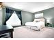 Green bedroom with white bedding and a modern desk, creating a serene and productive space at 15502 E Flower Mound Pl, Parker, CO 80134