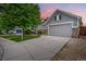 Charming gray home boasting stone accents and a two-car garage, set against a colorful twilight sky at 15502 E Flower Mound Pl, Parker, CO 80134
