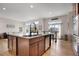 Spacious open kitchen featuring an island with a sink and seating, stainless appliances, and hardwood floors at 15502 E Flower Mound Pl, Parker, CO 80134