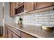 Kitchen featuring granite countertops, subway tile backsplash, and custom cabinetry at 15502 E Flower Mound Pl, Parker, CO 80134
