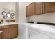 Functional laundry room features cabinetry and modern washer and dryer units at 15502 E Flower Mound Pl, Parker, CO 80134
