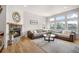 Bright living room with a stone fireplace and a large sectional sofa with large windows at 15502 E Flower Mound Pl, Parker, CO 80134