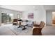 Bright living room features a comfortable gray sofa, accent chairs, and a sliding door with backyard views at 15502 E Flower Mound Pl, Parker, CO 80134