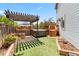 Private backyard features a hot tub under a pergola, a brick firepit, wooden stairs and artificial turf at 1526 Braewood Ave, Littleton, CO 80129