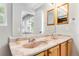 Bathroom with double sink vanity, unique faucets, and views of the back yard at 1526 Braewood Ave, Littleton, CO 80129