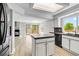 Open kitchen and living area with a large island, modern appliances, and sliding glass doors at 1526 Braewood Ave, Littleton, CO 80129