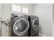 Modern laundry room equipped with front loading washer and dryer units for convenience at 1526 Braewood Ave, Littleton, CO 80129