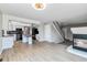 Open-concept living space features wood-look flooring, a fireplace, kitchen, and staircase at 1526 Braewood Ave, Littleton, CO 80129